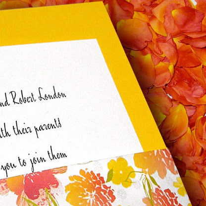 Bulk orange ombre gradient rose petals for fall weddings – Prime Petal Company. Floral-patterned invitation card with a yellow border on a bed of rose petals