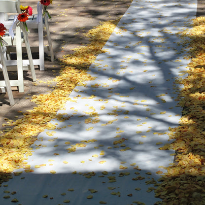 Bulk yellow rose petals for bright wedding aisle and party décor – Prime Petal Company. Decorative wedding aisle -pathway with yellow petals and white chairs on a sunny day.