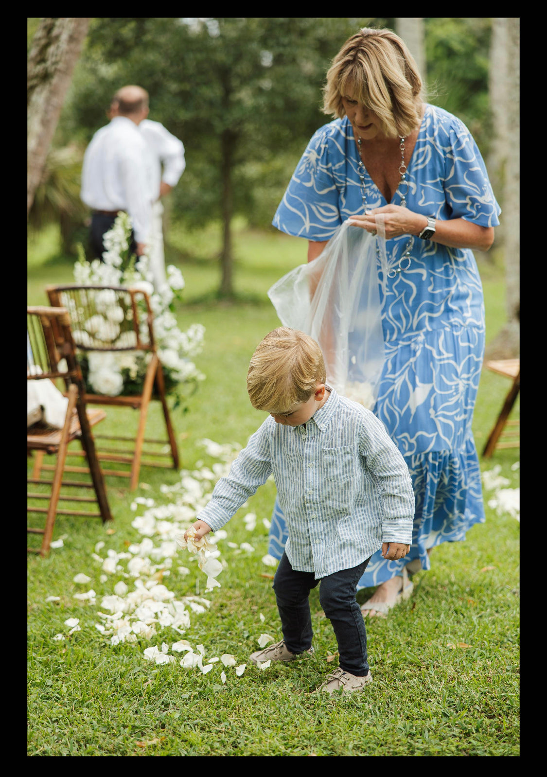 Bulk ivory rose petals for elegant wedding aisle and event décor – Prime Petal Company. Woman and child in a garden tossing ivory rose petals on the outdoor wedding aisle.