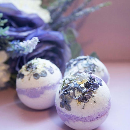 Three bath bombs made with lilac flower petals