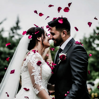 Bulk ruby rose petals for weddings and romantic events – Prime Petal Company. wedding couple surrounded by red rose petals outdoors.